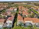 Aerial view of a residential community with tile roofs, palm trees, and screened-in pools at 231 Brunello Dr, Davenport, FL 33897