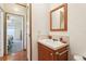 Well-lit bathroom features a wood framed mirror, wood vanity, and neutral countertop with sink at 2557 Karen Dr, Mount Dora, FL 32757