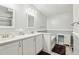 Bathroom features a long vanity with double sinks, tub, and gray accent tile at 2557 Karen Dr, Mount Dora, FL 32757