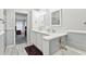 Bright bathroom with dual sinks, tub, gray tile accent, and tile floors at 2557 Karen Dr, Mount Dora, FL 32757