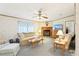 Inviting living room with neutral decor, a ceiling fan, fireplace and large windows at 2557 Karen Dr, Mount Dora, FL 32757