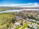 The aerial view showcases a waterfront community nestled amidst lush greenery and featuring well-maintained residences and roadways at 3221 Myakka River Rd, Tavares, FL 32778