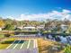 Aerial view of shuffleboard courts near pond with fountain, pool, and charming residential homes in a quiet neighborhood at 3221 Myakka River Rd, Tavares, FL 32778