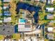 An aerial view captures the community amenities including a pool, tennis court, parking, and a picturesque pond at 3221 Myakka River Rd, Tavares, FL 32778