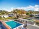 Aerial view features community pool, shuffleboard courts and residences, enhanced by trees and well-maintained landscaping at 3221 Myakka River Rd, Tavares, FL 32778