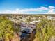 The aerial view shows a community with a boat dock on the lake surrounded by greenery, homes, and roadways at 3221 Myakka River Rd, Tavares, FL 32778