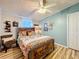 Cozy bedroom with a wooden bed frame, colorful bedding, and a ceiling fan at 3221 Myakka River Rd, Tavares, FL 32778