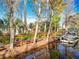 Waterfront property featuring a private dock, a boat, and access to a serene canal surrounded by beautiful trees at 3221 Myakka River Rd, Tavares, FL 32778