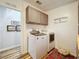 Efficient laundry room featuring overhead cabinets, a washer, and a dryer at 3221 Myakka River Rd, Tavares, FL 32778