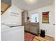 Bright laundry room featuring gray cabinets, a playful laundry sign, and a robot vacuum at 3221 Myakka River Rd, Tavares, FL 32778