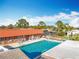 Community pool featuring clear blue water, seating, and building for residents' relaxation and enjoyment at 3221 Myakka River Rd, Tavares, FL 32778