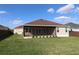 Exterior view of the house highlighting the screened lanai and backyard at 3290 Sennett Cir, Oxford, FL 34484