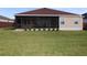 Exterior home view showing the screened lanai, backyard, and landscaping at 3290 Sennett Cir, Oxford, FL 34484