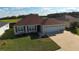 Charming single-story home featuring a three-car garage, red shutters and well-maintained lawn at 3290 Sennett Cir, Oxford, FL 34484