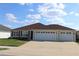 Welcoming one-story home with a three-car garage, well-kept lawn, and an attractive facade at 3290 Sennett Cir, Oxford, FL 34484