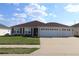 Inviting one-story home boasting a three-car garage, manicured lawn and pleasing curb appeal at 3290 Sennett Cir, Oxford, FL 34484