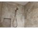 Updated shower featuring travertine tile and a shower niche for storage at 3290 Sennett Cir, Oxford, FL 34484