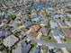 Aerial view of a single-Gathering home in a quiet neighborhood with lush landscaping and a nearby pond at 3330 Mayflower Loop, The Villages, FL 32163