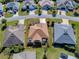 Aerial view of a single Gathering home featuring mature landscaping, a driveway, and an enclosed patio at 3330 Mayflower Loop, The Villages, FL 32163