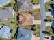 Aerial view of a single Gathering home featuring mature landscaping, a driveway, and an enclosed patio at 3330 Mayflower Loop, The Villages, FL 32163