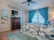 Comfortable bedroom with hardwood floors, ceiling fan, dresser, TV, and bright windows at 3330 Mayflower Loop, The Villages, FL 32163