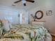 Bright bedroom featuring a ceiling fan, wood flooring, and a decorative woven mirror above a traditional dresser at 3330 Mayflower Loop, The Villages, FL 32163