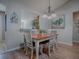 Charming dining room featuring wood floors, white chairs, and views into the kitchen at 3330 Mayflower Loop, The Villages, FL 32163