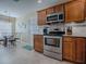 Well-equipped kitchen with stainless steel appliances, cherry cabinets, and adjacent dining area at 3330 Mayflower Loop, The Villages, FL 32163