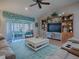 Spacious living room with custom built-ins, vaulted ceilings, ceiling fan, and sliding glass doors at 3330 Mayflower Loop, The Villages, FL 32163