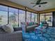 This sunroom is furnished with wicker furniture, a patterned blue rug and has great natural light at 3330 Mayflower Loop, The Villages, FL 32163