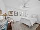 Bright bedroom featuring white bedding, a wood accent chair, and an eclectic design at 3400 Foxboro Ct, Mount Dora, FL 32757