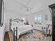 Bedroom with a wrought iron bed, patterned rug, and window with plantation shutters at 3400 Foxboro Ct, Mount Dora, FL 32757