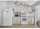 Cozy kitchen featuring white appliances, tile backsplash, and ample counter space at 3400 Foxboro Ct, Mount Dora, FL 32757