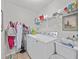 A conveniently located laundry room with washer, dryer, and storage shelving at 3400 Foxboro Ct, Mount Dora, FL 32757