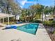 A beautiful pool area surrounded by lush tropical landscaping and comfortable outdoor furniture at 3400 Foxboro Ct, Mount Dora, FL 32757