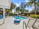 A beautiful pool surrounded by lush tropical landscaping and comfortable outdoor furniture at 3400 Foxboro Ct, Mount Dora, FL 32757