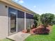 Well maintained backyard with green lawn and landscaped border with a glass door at 3540 O'Brien Pl, The Villages, FL 32163