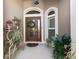 Welcoming front entrance featuring a decorative glass door, wreath, and manicured plants at 3540 O'Brien Pl, The Villages, FL 32163