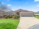 Charming single-story home featuring a well-manicured lawn, colorful landscaping, and a spacious three-car garage at 3540 O'Brien Pl, The Villages, FL 32163