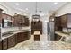 Spacious kitchen featuring dark wood cabinetry, granite countertops, and stainless-steel appliances at 3540 O'Brien Pl, The Villages, FL 32163