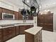 Well-equipped kitchen with dark cabinets, an island, and a hanging pot rack above at 3540 O'Brien Pl, The Villages, FL 32163