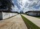 Long driveway flanked by well-maintained yards and a privacy fence, leading to the home at 390 Colonade Ct, Kissimmee, FL 34758