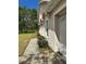 A side view of the home featuring a small sidewalk and green bushes at 390 Colonade Ct, Kissimmee, FL 34758