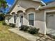 Close up of the front entrance and its stucco facade and manicured bushes at 390 Colonade Ct, Kissimmee, FL 34758