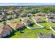 Scenic aerial view of homes in a suburban neighborhood, backing onto a tranquil lake and tree-lined horizon at 3935 Fescue St, Clermont, FL 34714