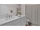 Well-lit bathroom with a white vanity, modern faucet, and patterned shower curtain at 3935 Fescue St, Clermont, FL 34714