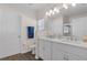 Bright bathroom featuring double sinks, white cabinets, quartz countertops, and a shower with glass doors at 3935 Fescue St, Clermont, FL 34714