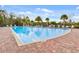 Large community pool with chairs for lounging in a tropical environment with palm trees at 3935 Fescue St, Clermont, FL 34714