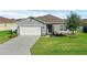 Inviting single-Gathering home featuring a two-car garage, a tidy lawn and tasteful landscaping at 3935 Fescue St, Clermont, FL 34714