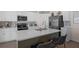 This spacious white kitchen features a quartz countertop island, stainless steel appliances and breakfast bar seating at 3935 Fescue St, Clermont, FL 34714